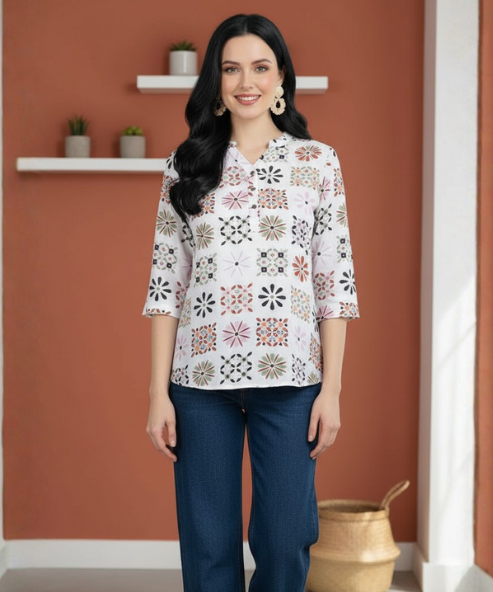 Woman wearing white geometric tile-print top with notch collar and three-quarter sleeves, paired with dark denim palazzo
