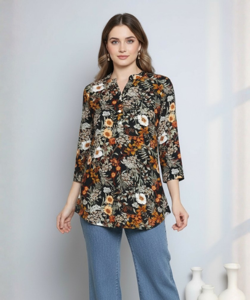 Woman wearing a black floral print tunic top with orange and white blooms, notch collar and 3/4 sleeves, paired with blue denim jeans.