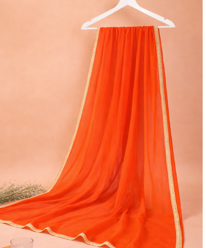 Orange chiffon dupatta with gold lace border draped on a hanger, sheer fabric with decorative trim